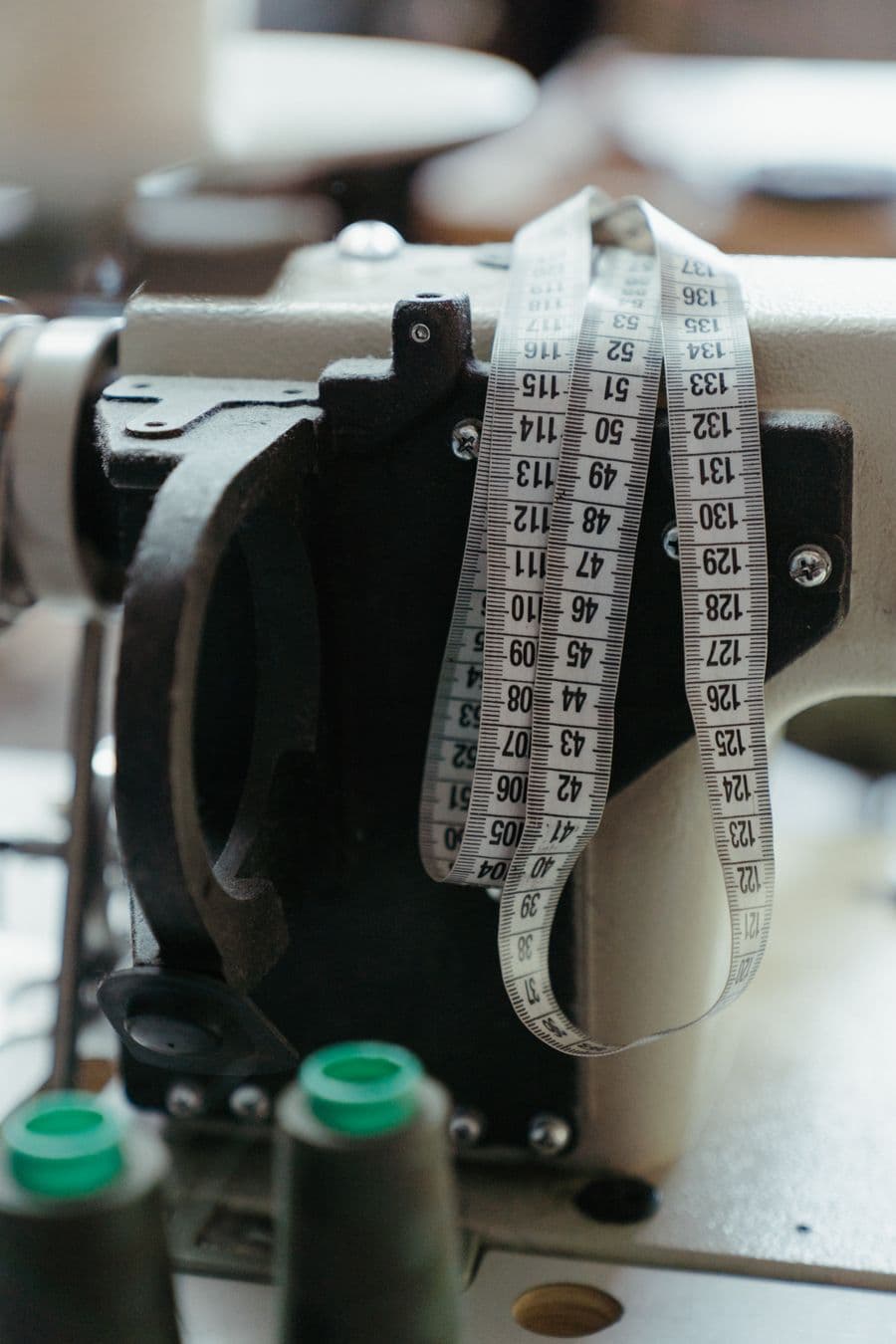 Cinta métrica colgada de una máquina de coser industrial